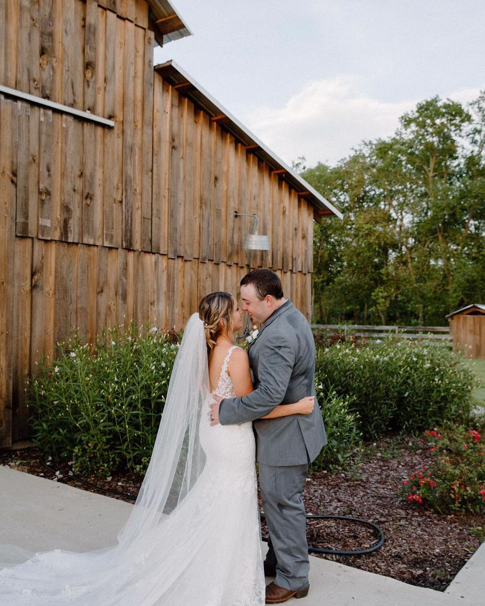 bride and groom in front of barn venue